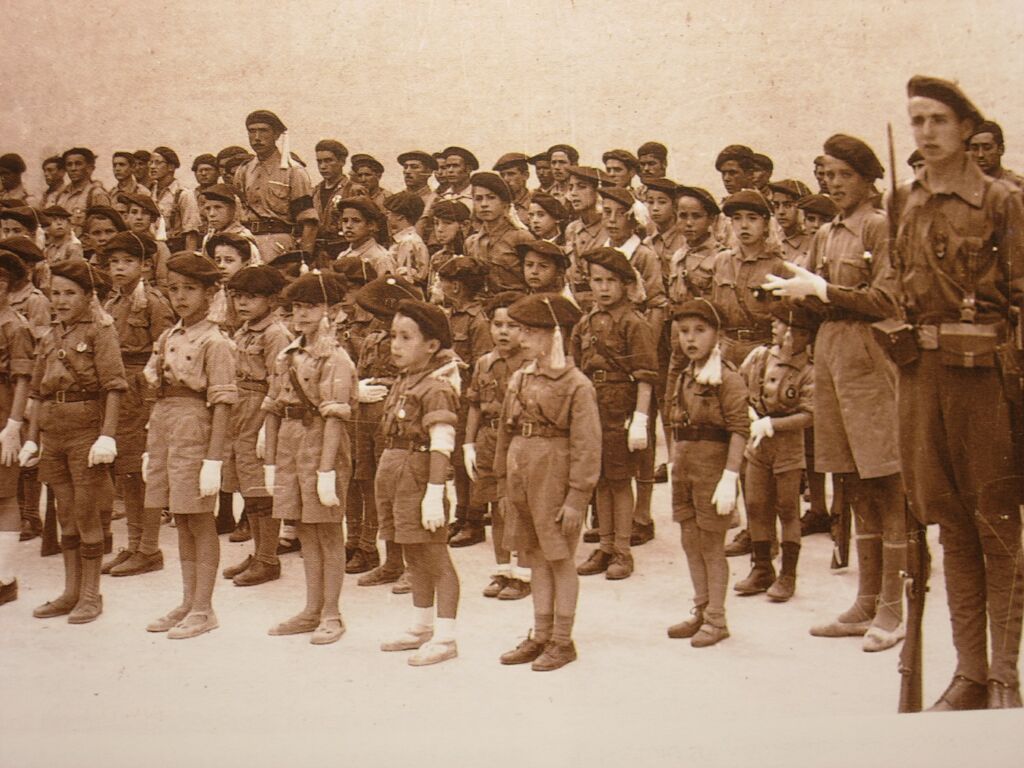 Pelaioen (ume karlisten) formazioa. Eskuinaldean Donostiako ekitaldian bandera espainola daraman erreketea